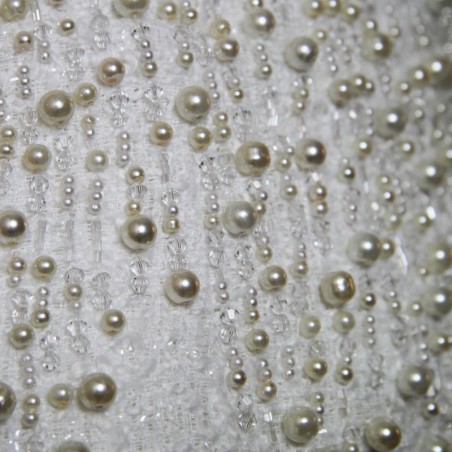 Gros plan sur les finitions en perles et la matière texturée de la robe bustier.