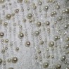 Gros plan sur les finitions en perles et la matière texturée de la robe bustier.