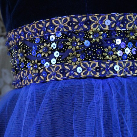 Close-up of metallic flower embroidery, sequins, and Swarovski crystals on blue velvet