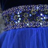 Close-up of metallic flower embroidery, sequins, and Swarovski crystals on blue velvet