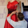 designer working on red satin evening midi dress