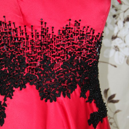 zoom on the black embroidery and hand applied couture embellishments of red satin evening dress