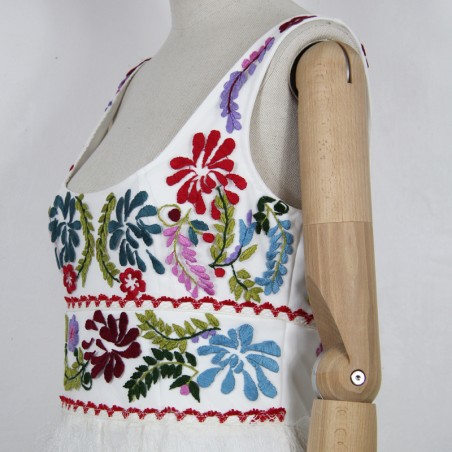 Gros plan sur les broderies artisanales sur le haut de la robe
