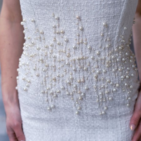 Gros plan sur les finitions en perles et la matière texturée de la robe bustier