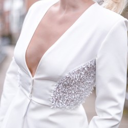 Tailleur pantalon couture blanc avec blazer à basque longue et broderies artisanales, idéal pour une occasion formelle.