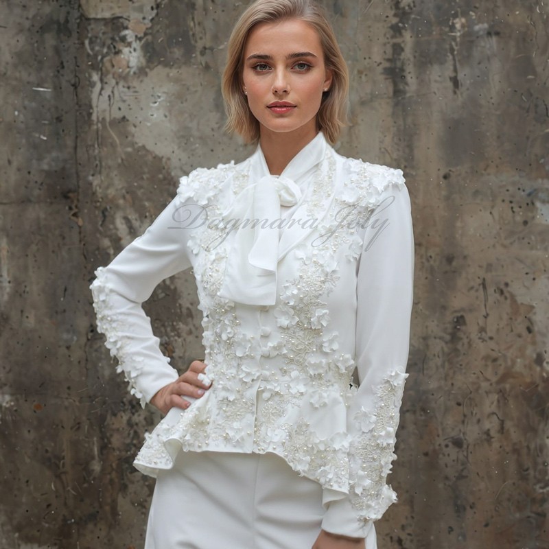 Tailleur de mariée moderne avec broderies florales et teinte ivoire douce, idéal pour un mariage minimaliste.