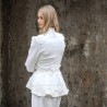 Gros plan sur les détails couture : appliqués floraux, boutons nacrés et dentelle délicate sur un tailleur de mariée.