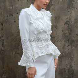 Mariée élégante posant avec assurance dans un tailleur de mariée raffiné aux accents romantiques.