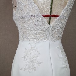 Back view of high slit sleeveless wedding dress on mannequin, featuring V-back and lace with crystal embellishments