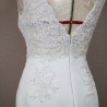 Robe de mariée sur mannequin, dos nu plongeant avec ornements en dentelle