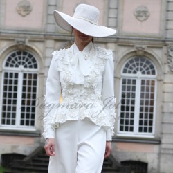 Bride wearing a couture white pantsuit with wide-leg trousers and tailored blazer, embellished with lace and pearl details.