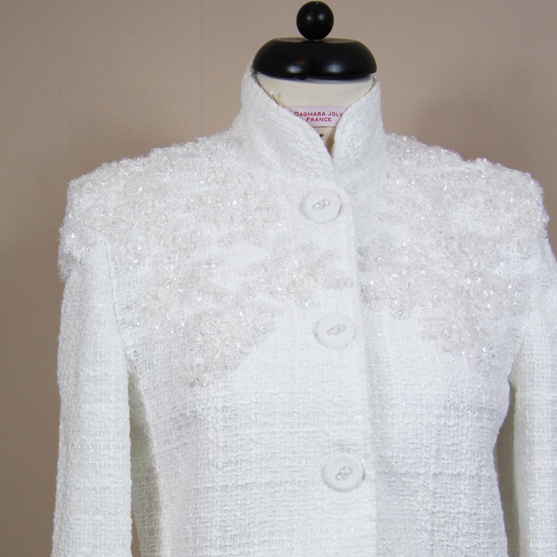 Gros plan sur les détails brillants d’une veste en tweed blanc