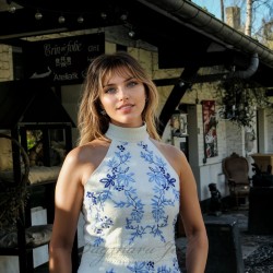 Close-up of hand embroidery on ivory linen dress bodice