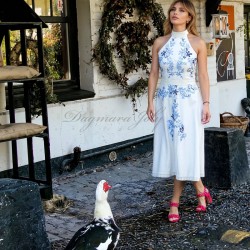 Model wearing ivory embroidered midi dress in garden