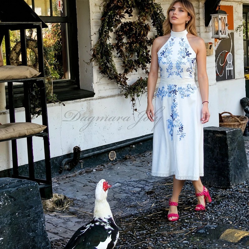 Model wearing ivory embroidered midi dress in garden