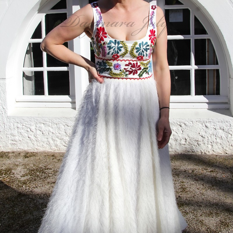 Model wearing handmade white wedding dress with floral embroidery
