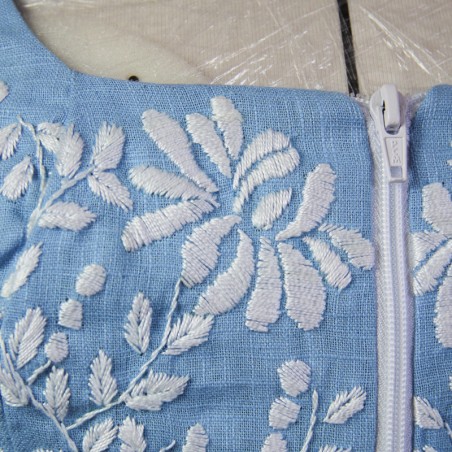 Gros plan sur la broderie florale faite main sur lin blue