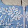 Gros plan sur la broderie florale faite main sur lin blue
