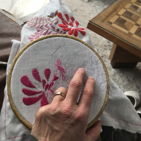 Travail en cours : broderie à la main sur tissu en lin pour robe de mariée artisanale