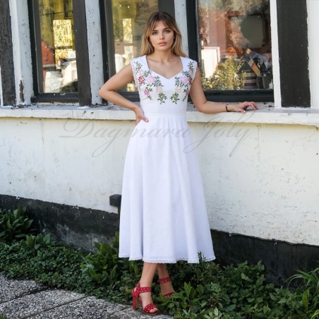 Robe de mariée midi en lin portée par une mariée dans un jardin, avec un décolleté cœur et une jupe fluide