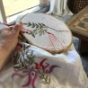 Zoomed-in stitches showing artisanal embroidery on linen dress