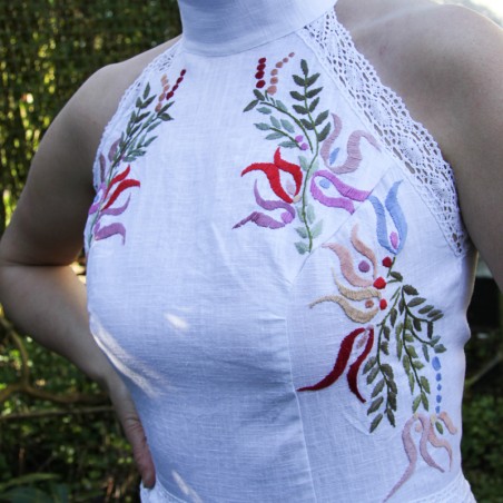 Close-up of hand-embroidered detail on white linen bridal dress