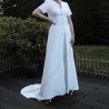 Mariée pose dans un ensemble de mariage moderne, traîne longue flottant derrière elle