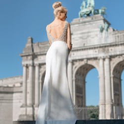 Back view of model in handmade French bridal dress featuring deep V back, long elegant train, and pearl details