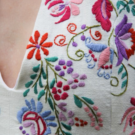 Zoom sur la broderie florale de la robe dos nu