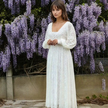 Gros plan sur la robe mettant en valeur des motifs floraux en dentelle fine