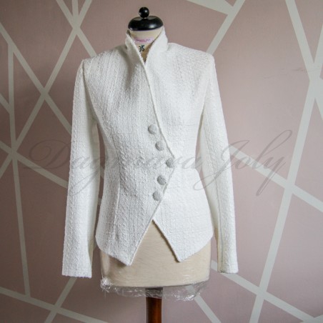 Vue de face de le blazer blanc asymétrique en tweed pour femme avec coupe ajustée.
