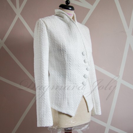 Vue de côté de la veste blanche asymétrique en tweed soulignant sa silhouette élégante.