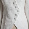 Close-up of women's white bridal asymmetrical tweed jacket fabric showing textured tweed and stitching.