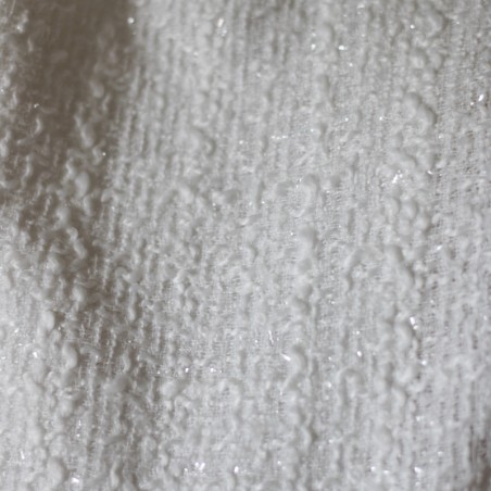 Close-up of women's white bridal asymmetrical tweed jacket fabric