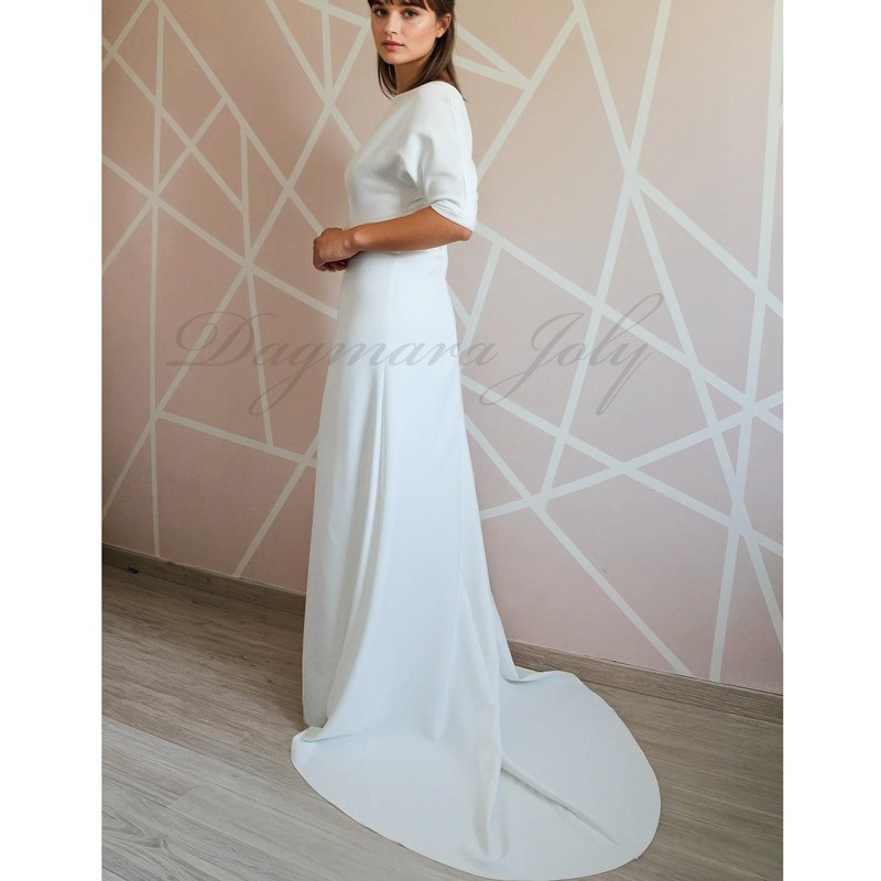 Back view of a floor-length wedding gown with dolman sleeves and a dramatic cathedral train extending gracefully behind Back view of a floor-length wedding gown with dolman sleeves and a dramatic cathedral train extending gracefully behind