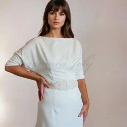 Gros plan sur le corsage de la robe de mariée longue fourreau, montrant les détails brodés et la texture légère des manches