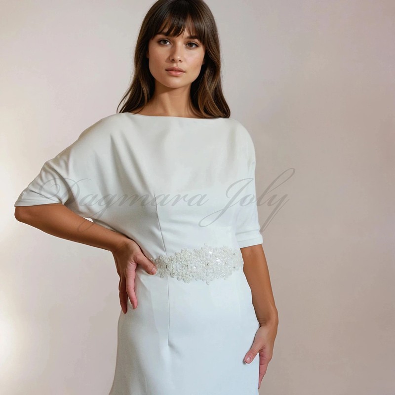 Gros plan sur le corsage de la robe de mariée longue fourreau, montrant les détails brodés et la texture légère des manches