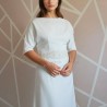 Gros plan sur le corsage de la robe de mariée longue fourreau, montrant les détails brodés et la texture légère des manches