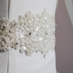 Gros plan sur la dentelle de la robe de mariée longue fourreau,  brodés à la main