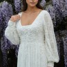 Close-up of the dress’s neckline showing delicate lace and pearl embellishments on sheer fabric