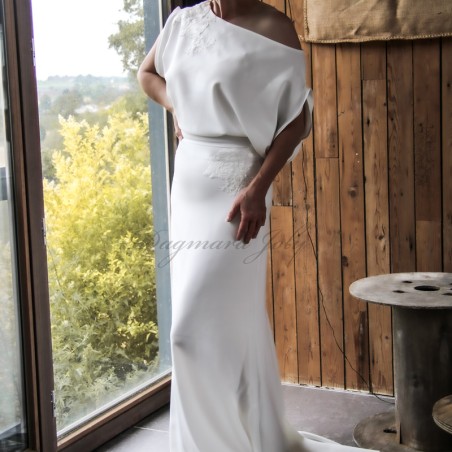 Bride walking in off-shoulder sheath wedding gown with train flowing behind