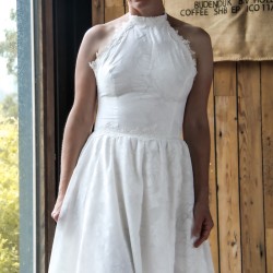 Cliché naturel d’une modele dans une robe de mariée sur mesure fabriquée en France, avec dos nu et accents de dentelle.