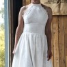 Cliché naturel d’une modele dans une robe de mariée sur mesure fabriquée en France, avec dos nu et accents de dentelle.