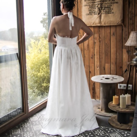 Back view of a handmade wedding gown with open halter back, lace detailing, and floral cotton fabric.