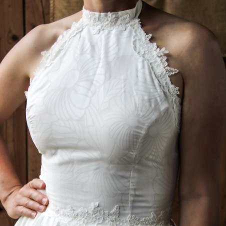 Close-up of intricate lace details on the bodice of a cotton halter neck wedding dress