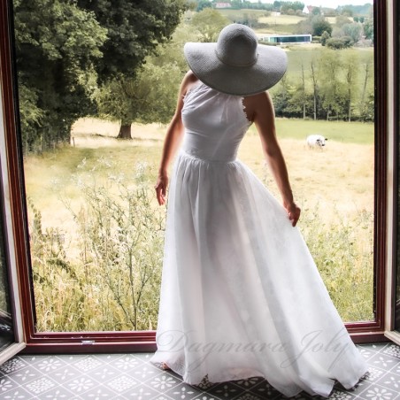 Model showcasing a romantic halter neck bridal gown, custom-fitted and crafted in France.
