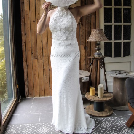 Front view of a minimalist wedding gown with halter neckline, hand-cut floral embellishments, and flowing train.