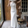 Front view of a minimalist wedding gown with halter neckline, hand-cut floral embellishments, and flowing train.