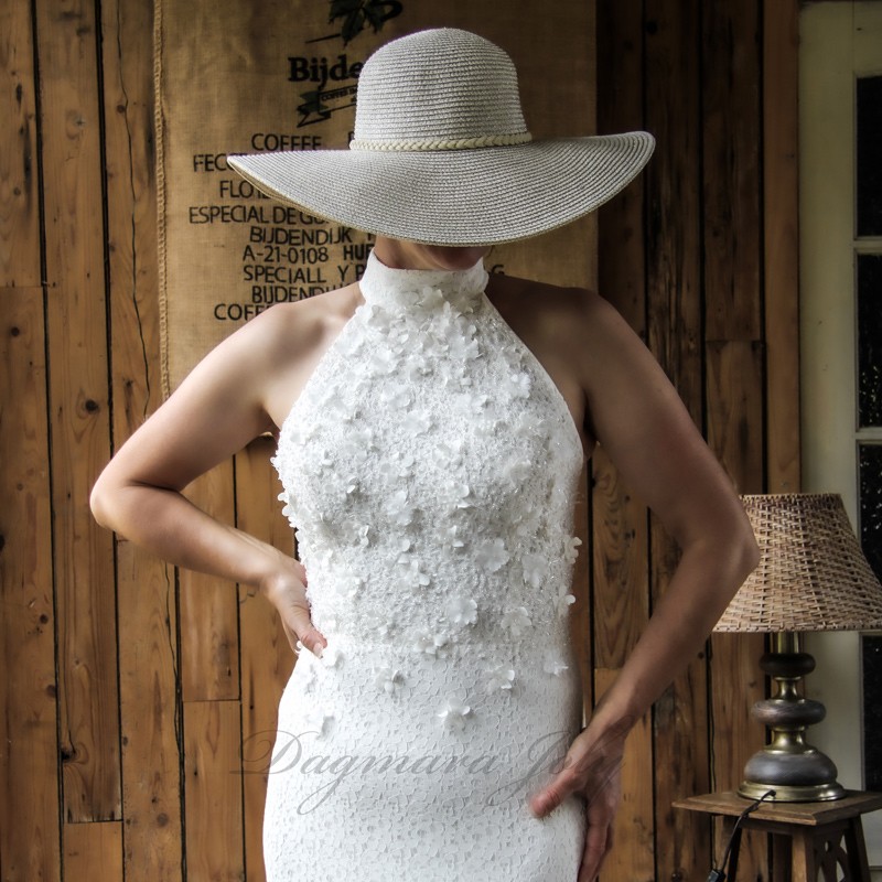 Bride wearing a modest halter neck sheath wedding dress with train, made of delicate cotton lace. Bride wearing a modest halter neck sheath wedding dress with train, made of delicate cotton lace.