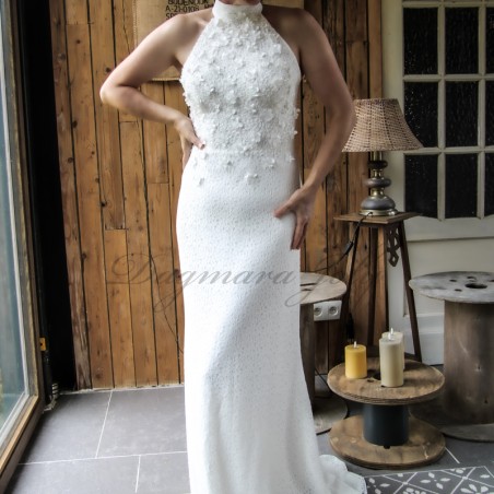 Bride standing gracefully in a sheath wedding dress with train, highlighting the dress’s clean lines and minimalist design.